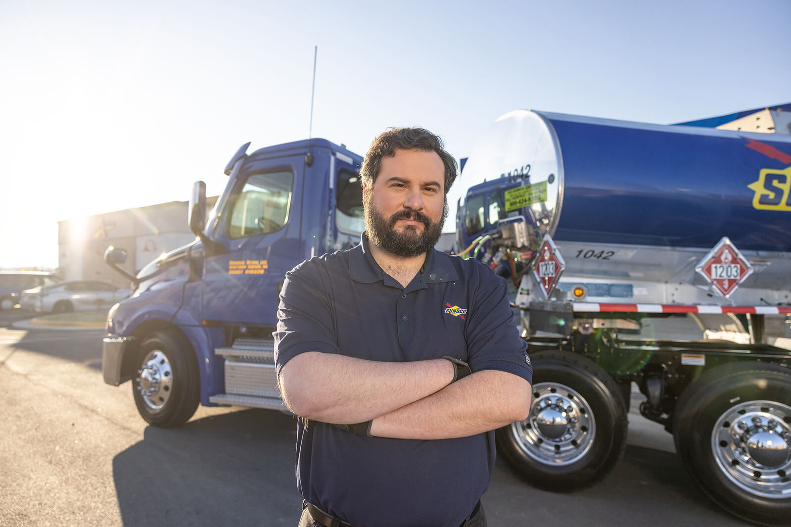 Truck driver in front of large truck smiling